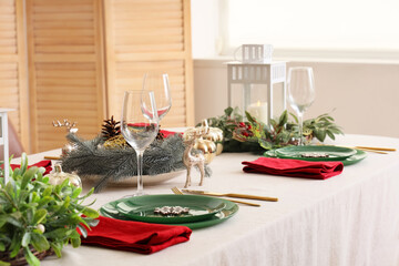 Beautiful table setting for Christmas dinner in light room