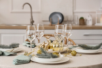 Christmas table setting with fir branches in kitchen