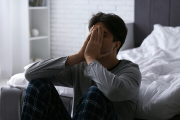 Depressed young man in bedroom