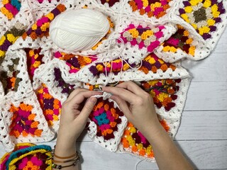 Crocheting granny square blanket process and woman's hands hobby handmade handiwork clews and hook cozy winter autumn fall photo