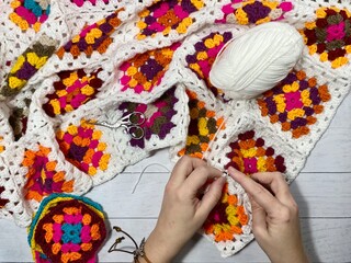 Crocheting granny square blanket process and woman's hands hobby handmade handiwork clews and hook cozy winter autumn fall photo
