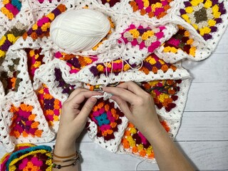 Crocheting granny square blanket process and woman's hands hobby handmade handiwork clews and hook cozy winter autumn fall photo