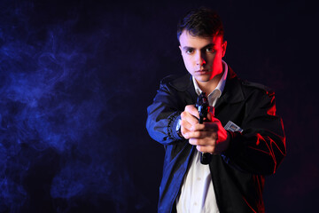 Male FBI agent with gun on dark background