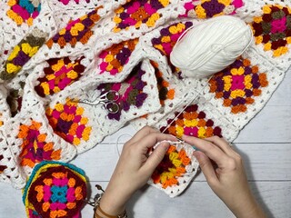 Crocheting granny square blanket process and woman's hands hobby handmade handiwork clews and hook cozy winter autumn fall photo