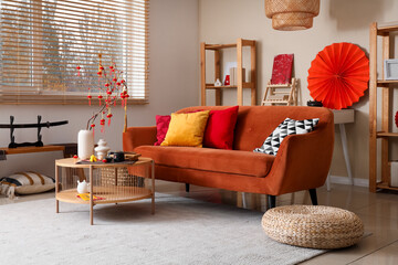 Interior of living room decorated for Chinese New Year with red sofa and tea set on table