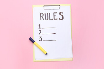 Clipboard with blank list of rules on pink background