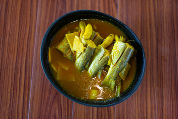 Mullet fish curry in a bowl on a wooden table