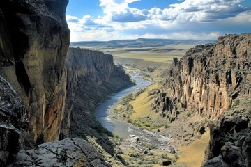 Majestic cliffs rise above the tranquil river in a stunning canyon view.