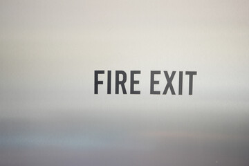 Fire Exit Signage prominently displayed in an Urban Environment alongside a Yellow Taxi cab