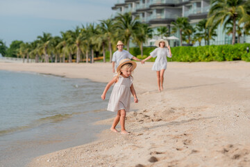 Happy family enjoying vacation on the beach together having fun on summer vacation.