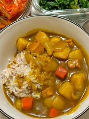A comforting bowl of Japanese curry, featuring a rich, savory sauce with tender vegetables and chunks of meat, served over fluffy rice. A warm, flavorful dish perfect for any meal.
