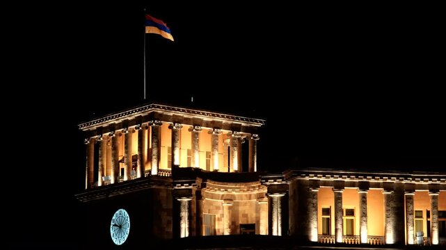 Tripod shot of Armenian National flag waiving on the Clock Tower of Government building at night. Yerevan, Armenia.