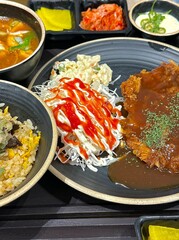 Crispy tonkatsu, a Japanese-style breaded and deep-fried pork cutlet, served with shredded cabbage and drizzled with savory sauce. A delightful balance of crunchy texture and juicy meat.
