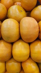 Close up pile of tasty fresh oranges sold at the market as a background.