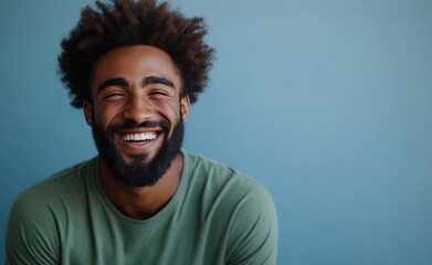 A man with a beard is smiling and wearing a t-shirt