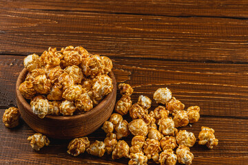 Snack concept, sweet caramelized popcorn in a bowl on a gray, wooden background