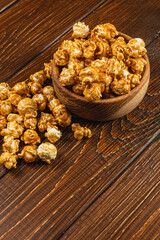 Snack concept, sweet caramelized popcorn in a bowl on a gray, wooden background