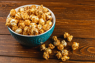 Snack concept, sweet caramelized popcorn in a bowl on a gray, wooden background