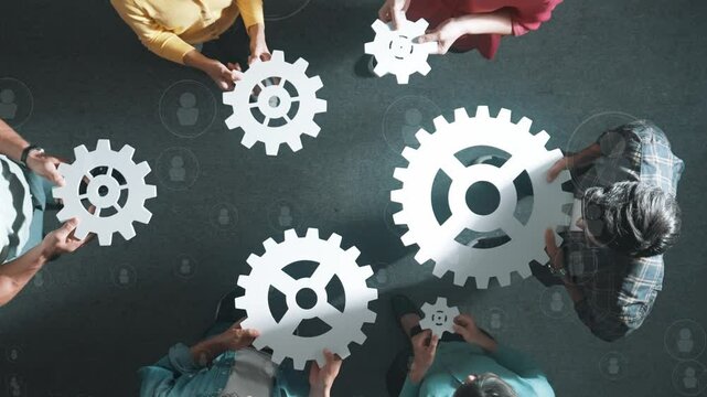 Top view of skilled business people joining and gathering white gear together. Diverse team working together to put or collect cog with networking communication and data base connection. Symposium.