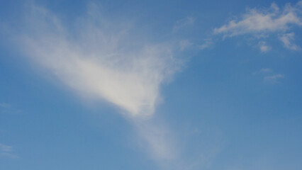 blue sky with white clouds. The sky is clear and bright, and the clouds are scattered throughout the sky. Scene is peaceful and serene, as if the viewer is looking up at a beautiful day
