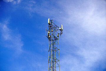 Communication Tower Under Blue Sky with Wispy Clouds Above