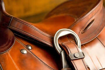 Obraz premium A detailed close-up of a polished brown leather saddle with sturdy stitching and a silver ring attachment, highlighting durability and traditional craftsmanship