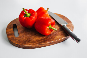 fresh red bell peppers on wooden chopping board, simple natural healthy ingredients