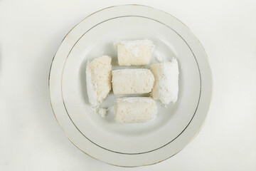 White rice cakes are neatly arranged on a plate on the table