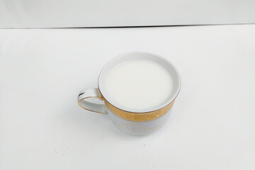 White milk in a white glass on a white table