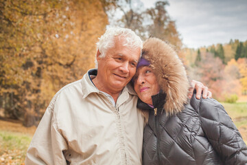 Happy romantic senior couple hugging and enjoying retirement outdoor