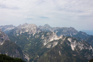 Hiking trail with scenic view of rugged mountain peak Jalovec and Mangart, Julian Alps. Triglav...