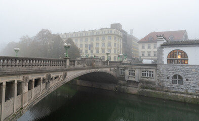 Naklejka premium Dragon bridge in ljubljana covered by fog in a cold winter morning. Slovenia, Europe