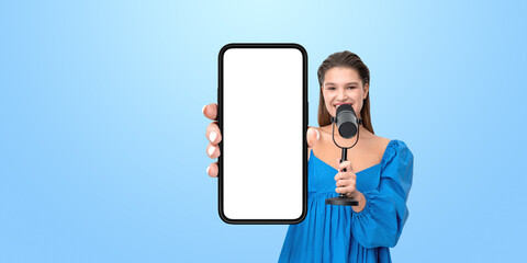 Woman in a blue blouse holding a smartphone with a blank screen