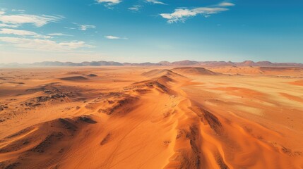 cinematic photography drone angle looking down on to dusty arid desert, vibrant red sand, epic view, blue sky