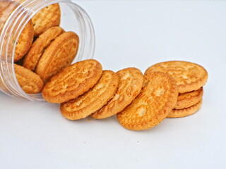 close-up of a biscuit coming out of a clear jar on a white background
