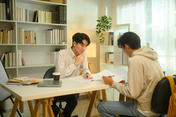 Asian male student studying with tutor at home. Education, knowledge and tutoring concept