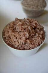 a bowl of riceberry rice : close-up pile of rice called riceberry rice, rice with high nutrients on white background. purple rice.