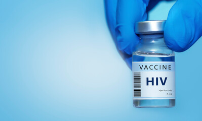 A doctor holds a vial of the HIV vaccine. Experimental HIV vaccine vial for immunization against HIV disease. Copy space