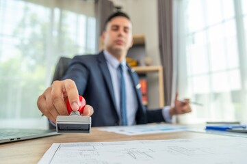 Businessman stamping document with approved stamp