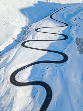 Aerial view of the winding road over the  Julier Pass in Swiss Alps mountain in winter full of snow, Canton Grison, Switzerland