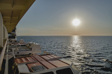 Breathtaking sunset sunrise ocean view from outdoor teak pool promenade deck of ocean liner at sea...