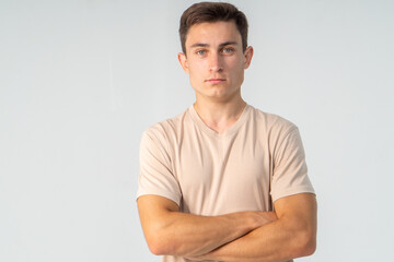 Young confident man in T-shirt close-up on a white background, copy space