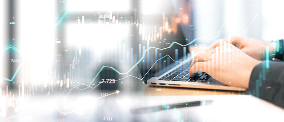 Hands typing on a laptop with overlay of financial graphs and charts representing global trading, market analysis, and economic trends.