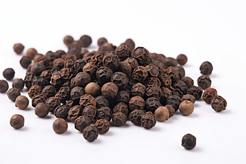 High-quality close-up of rounded black peppercorns scattered on a clean white background, showcasing their texture and natural details