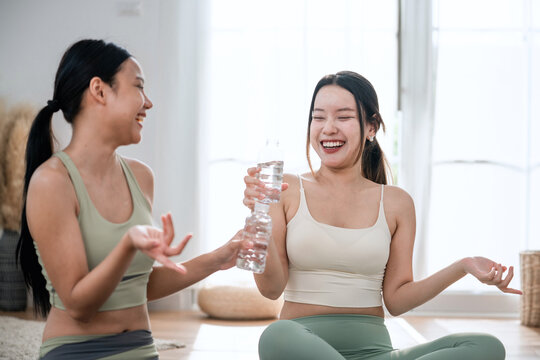 Beautiful girl relaxing doing yoga with class mates.