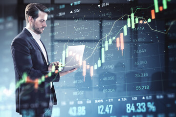 Businessman analyzing stock market data on laptop with financial graph overlayed on digital screen in office environment.