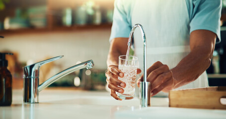 Person, tap and hands with glass of water in kitchen for fresh drink, liquid and hydration. Sink...