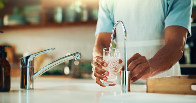 Person, tap and hands with glass of water in kitchen for fresh drink, liquid and hydration. Sink closeup, thirsty or pouring pure beverage in container for nutrition, drinking or filtration in home