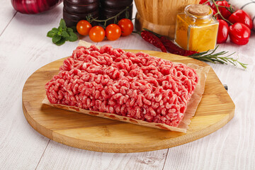 Raw minced beef meat over board