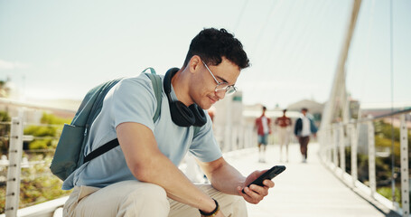 Phone, student and man at college outdoor for schedule, learning or online education by bridge. Relax, mobile and person at university campus to check test results, research or reading text message